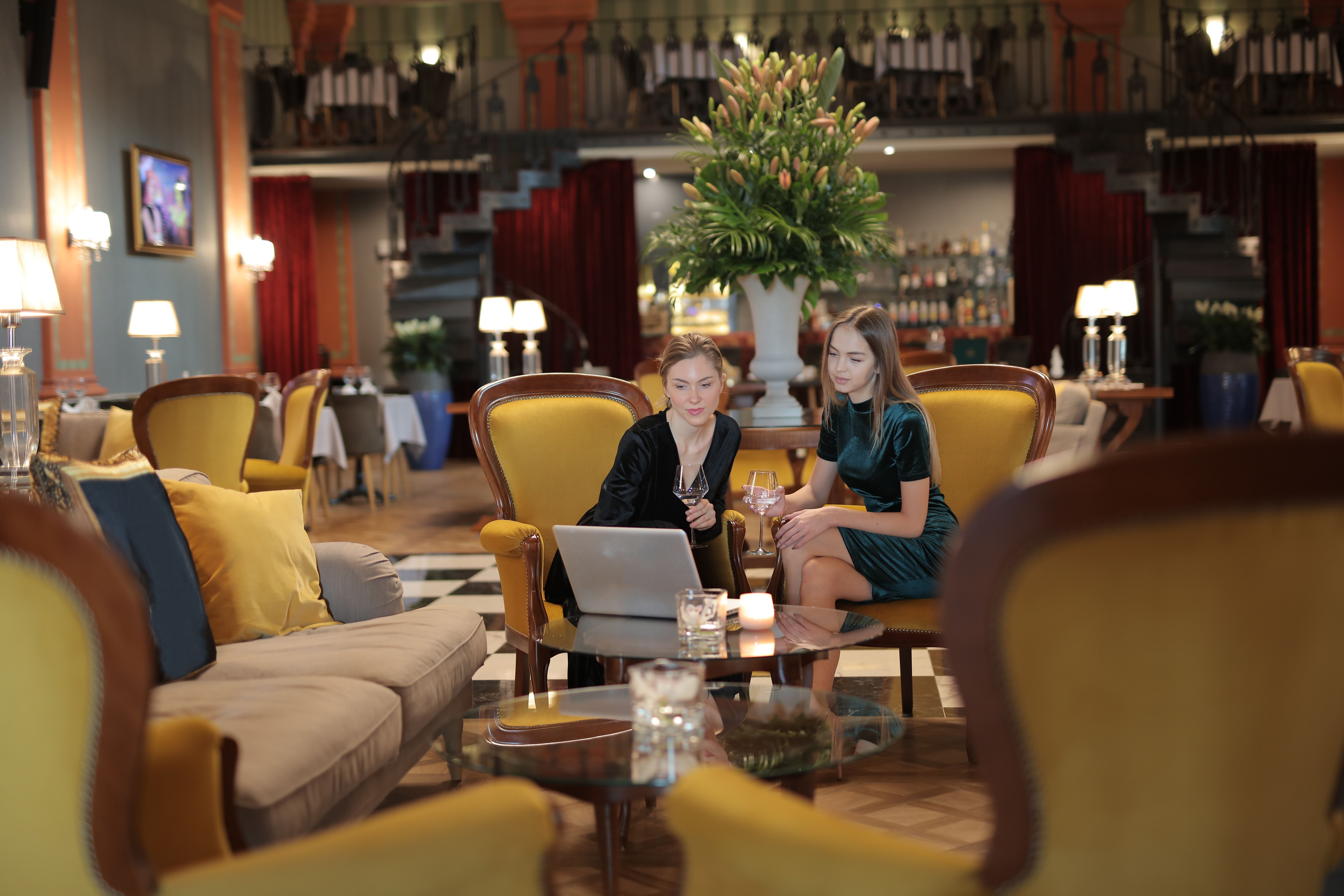 Two women enjoying an elegant conversation in a luxury hotel lounge
