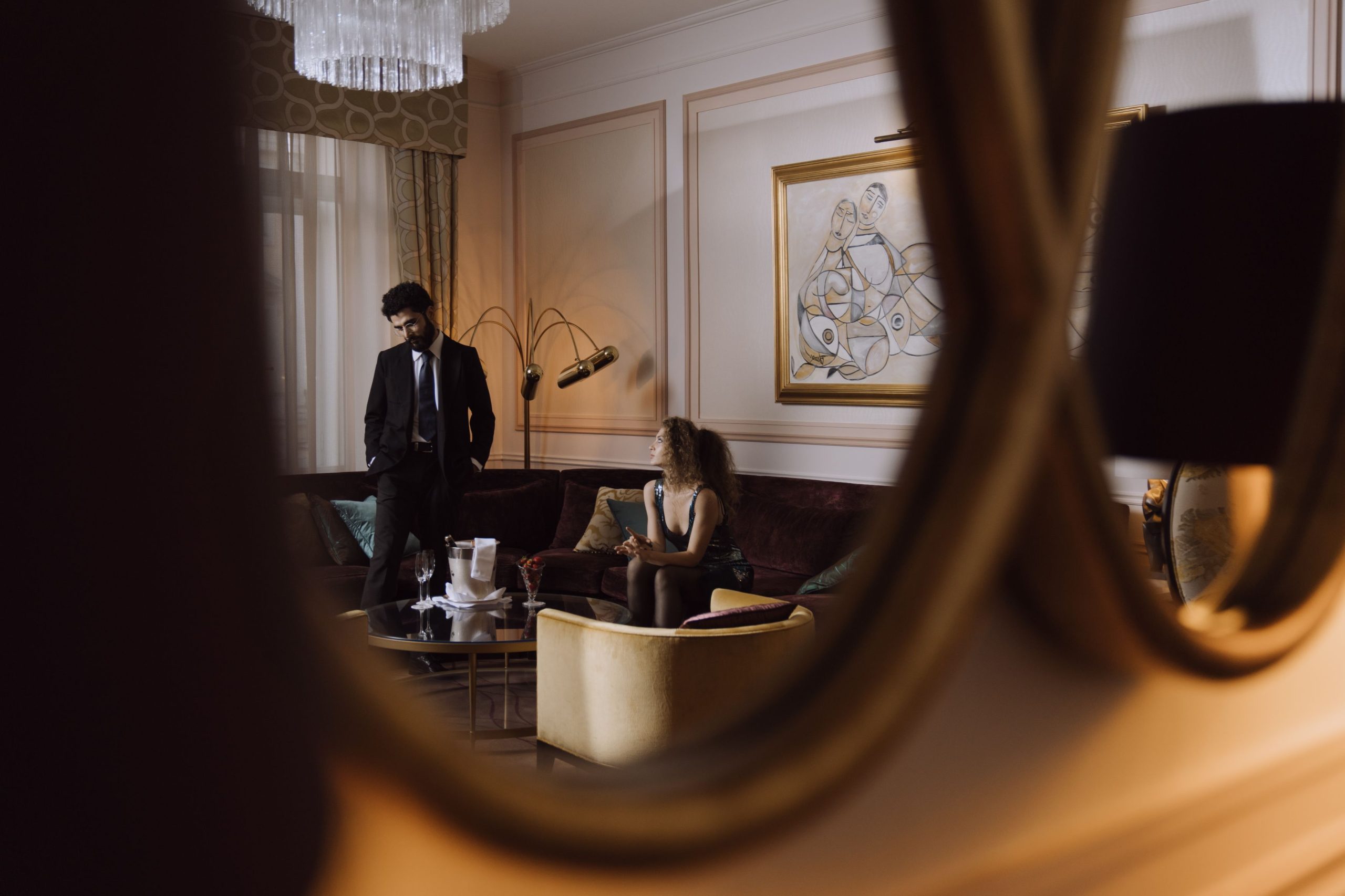 An elegant couple sharing conversation in a luxurious hotel lounge