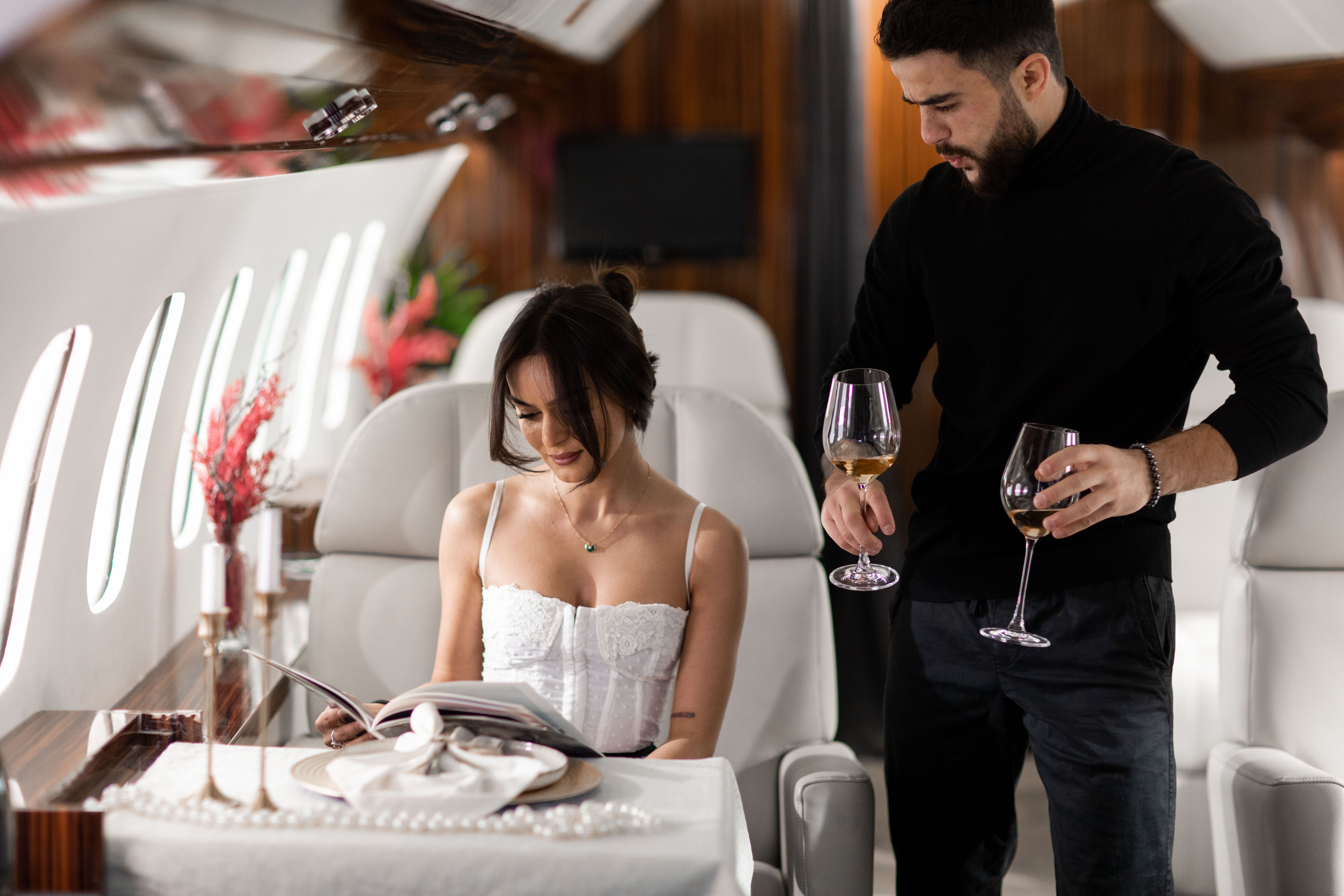 Elegant couple enjoying wine in a luxurious private jet interior