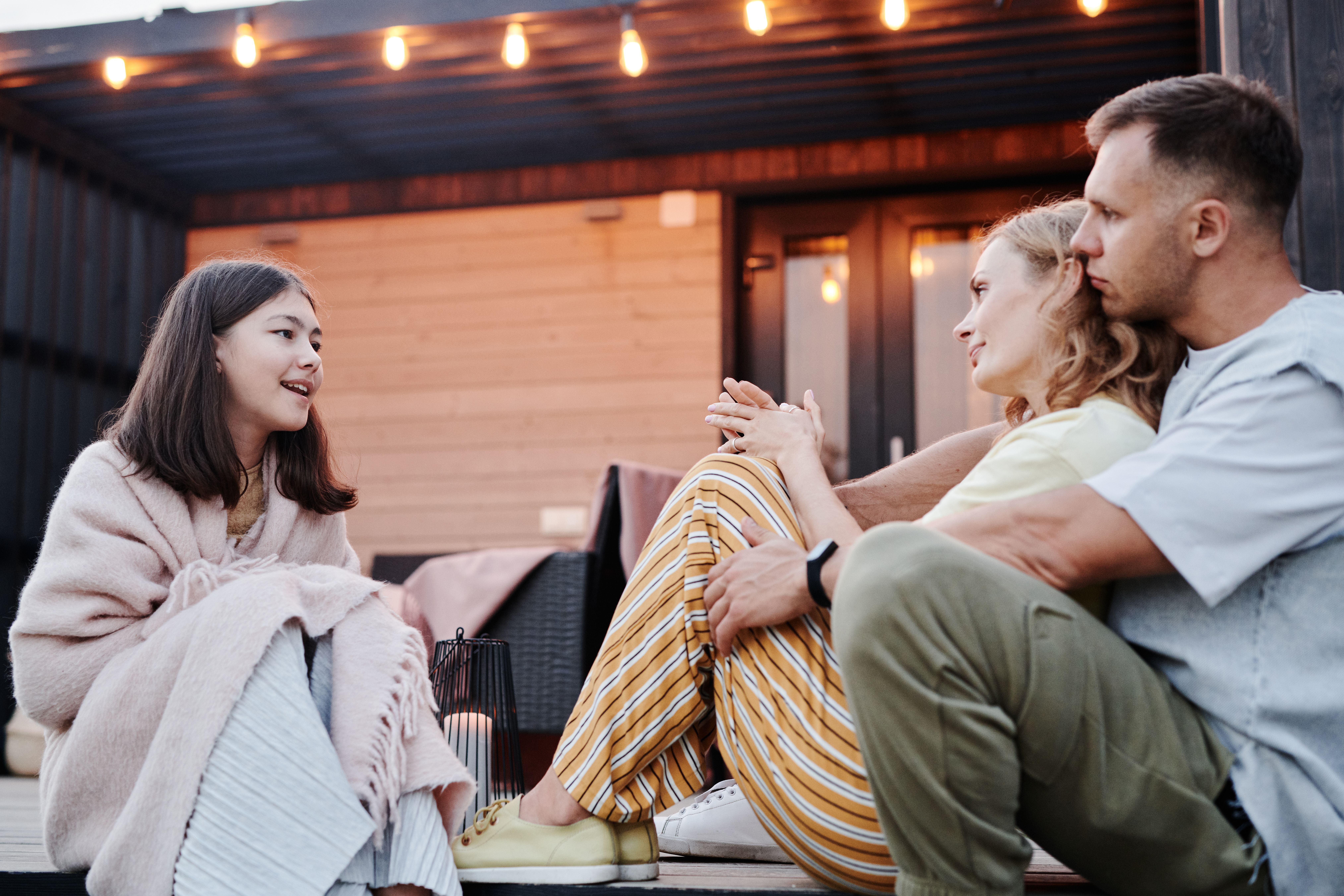 Family talking together on a cozy outdoor patio in the evening
